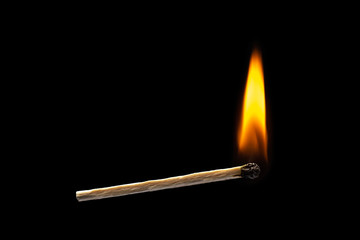 Orange fire of atchstick on black background. horizontal