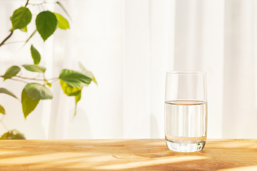 glass of water on wooden table, sunny morning, copy space for your text