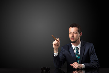 Businessman holding cigarette in his hand and wearing suit.