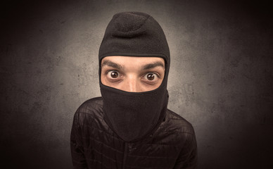 Burglar standing in black clothes and balaclava on his head.