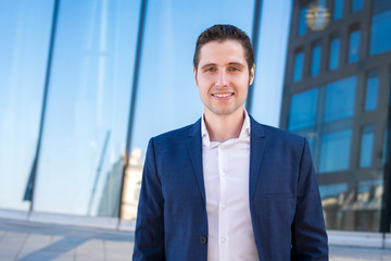 Handsom young businessman portret on blue industrial background © Dmitrii