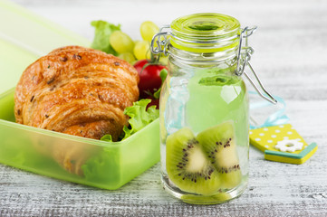 Water with kiwi and green lunch box