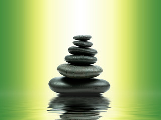 Zen basalt stones with green bamboo on water. Spa and Wellness concept.