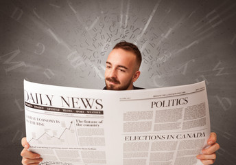 Young smart businessman reading daily newspaper with alphabet letters above his head