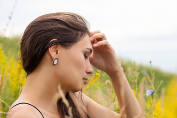 portrait of a young girl in profile in the grass