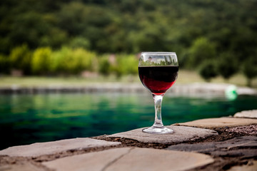 Drink in tall glass in poolside. Refreshment on summer day. Purple juice cocktail or vine.