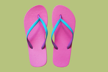 Pink flip flops isolated on green background. Top view
