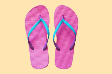 Pink flip flops isolated on yellow background. Top view
