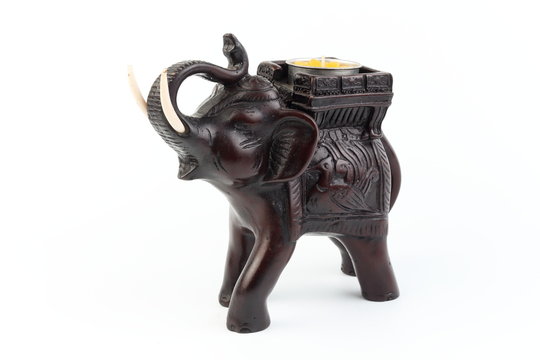 Black elephant made of resin like wood carving with candle holder with white sesame. Stand on white background, Isolated, Art Model Thai Crafts, For decoration Like in the spa.