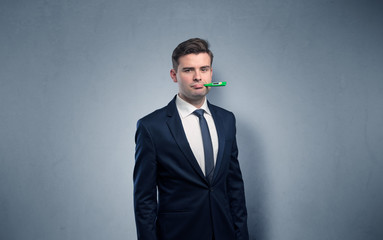 Young tired businessman with thermometer and copy space

