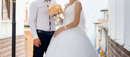 Newlyweds stand on a narrow street