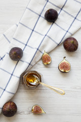 Obraz premium Top view glass jar of fig jam and fresh figs on white wooden background. Overhead, from above.