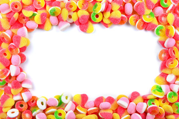 Frame of assorted gummy candies isolated on white. Top view. Space for text or design.