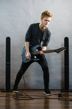 Young man playing electric guitar