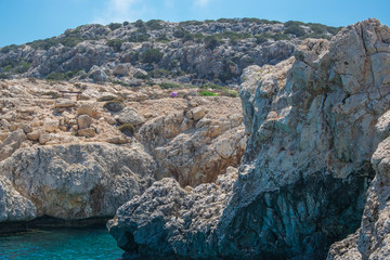 A rocky shore in a blue lagoon on the island of Cyprus.