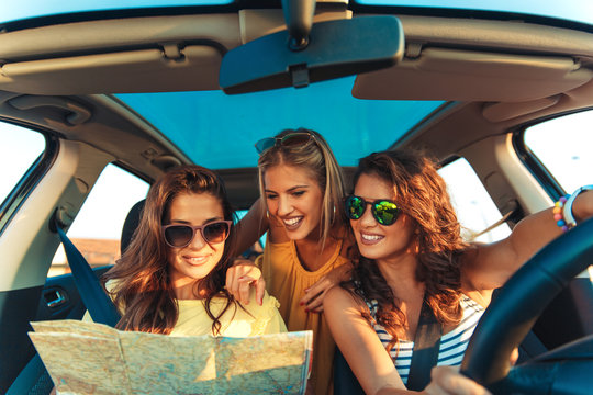 Three female friends enjoying traveling in the car.