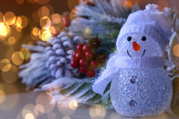 Happy snowman standing in winter with bokeh light