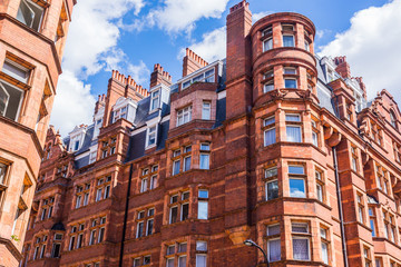 Opulent British Victorian terraced luxury residential building in red bricks in Mayfair, London, UK - 218682234