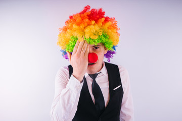 Office worker in clown wig, clown concept at work. Businessman with clown wig isolated on white