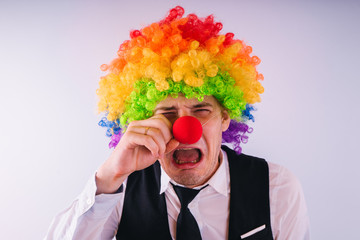 Office worker in clown wig, clown concept at work. Businessman with clown wig isolated on white