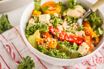 Healthy vegan salad with roasted vegetables, tahini, quinoa and kale. Clean eating concept.
