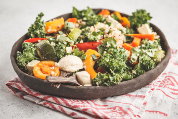 Healthy vegan salad with roasted vegetables, tahini, quinoa and kale. Clean eating concept.