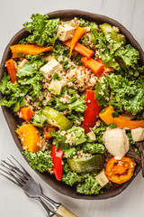 Healthy vegan salad with roasted vegetables, tahini, quinoa and kale. Clean eating concept.