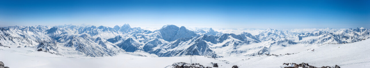 Fototapeta na wymiar Snowy Greater Caucasus ridge with the Mt. Ushba at winter sunny day. Panoramic view from Pastuchova kliffs at Elbrus ski slope, Kabardino-Balkaria, Russia