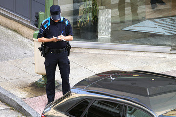 policeman writing fine ticket for car bad parking