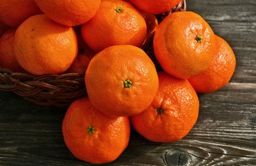 A lot of fresh Mandarin orange in basket with wooden background.