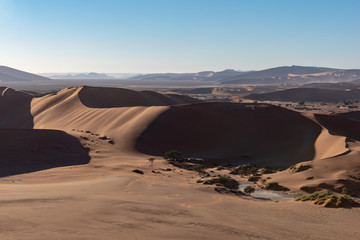 Fototapeta premium Aerial view of red desert dunes in morning light at Sossusvlei, Namibia