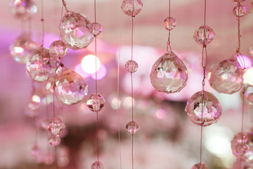 Chandelier light in interior, Chrystals close-up. crystal part from chandelier. Pink colors