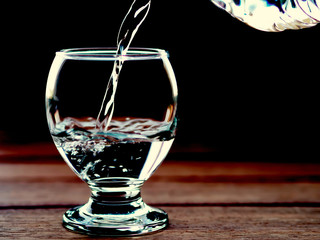 water glass and water bottle with water filling and black background