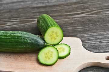 Cucumber seeds are edible and very nutritious..Fresh Cucumber slice on wooden board with wooden background.