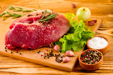 raw fresh meat on the table for cooking with salad and spices