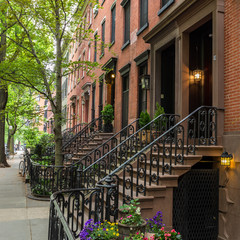 Row of old brownstone buildings along an empty sidewalk block in the Greenwich Village neighborhood...