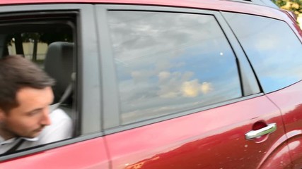 Man Backs Up Into Parking Spot, In City, He Looks Over His Shoulder, Then Uses His Rearview Mirror - Powered by Adobe