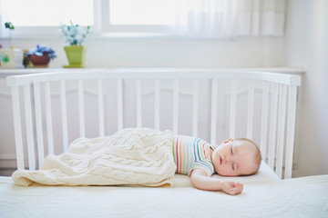 Baby girl sleeping in co-sleeper crib