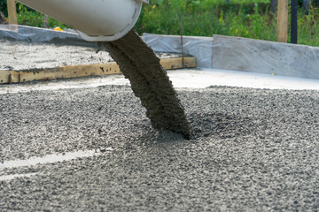 Pouring concrete from a concrete mixer. The work of people pouring concrete.