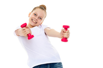 Little girl doing exercises with dumbbells.