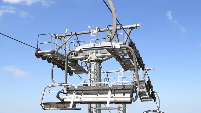 Ski chair lift station on mountain top, summertime stationery, rotating anemometer blue sky in background
