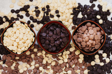 An assortment of fine white, dark, and milk chocolate in bowls overhead