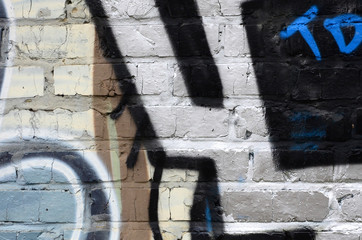 Fragment of graffiti drawings. The old wall decorated with paint stains in the style of street art...
