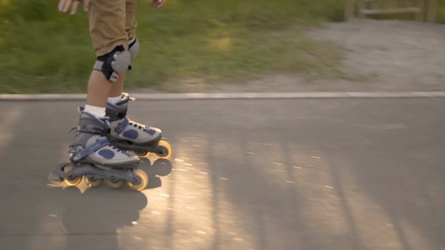 Rides roller skates. Boy rolls on rollers