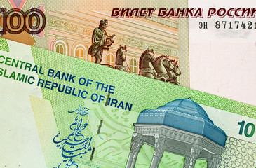 A close up image of an Iranian 10000 rial note with a Russian 100 ruble bank note