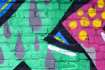 Fragment of graffiti drawings. The old wall decorated with paint stains in the style of street art culture. Colored background texture
