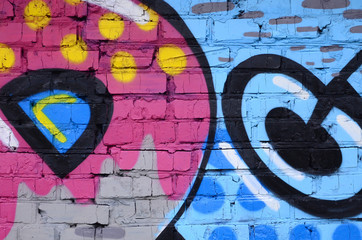 Fragment of graffiti drawings. The old wall decorated with paint stains in the style of street art culture. Colored background texture