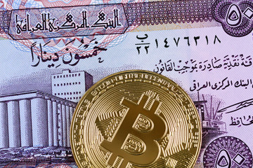 Close up image of an Iraqi 50 dinar bank note with a golden bitcoin