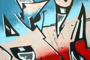 Fragment of graffiti drawings. The old wall decorated with paint stains in the style of street art culture. Colored background texture