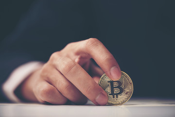 Golden Bitcoin in a man hand, Digitall symbol of a new virtual currency